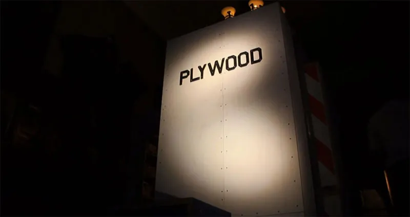 A photo of a sculpture Tom Sachs dedicated to his love of plywood. It features the word 'PLYWOOD' cut from black-painted plywood.